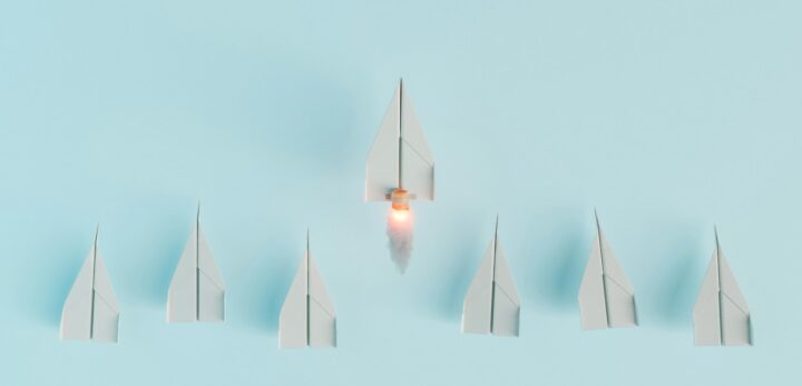 the impact of executive leadership on company culture and innovation paper airplanes in a line with one taking off to symbolize leadership