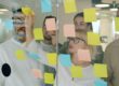 Marketing team brainstorming with sticky notes to design workflow and team structure